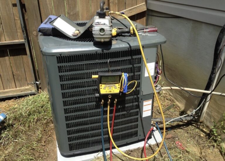 Gauges connected to an outdoor AC condenser during a repair